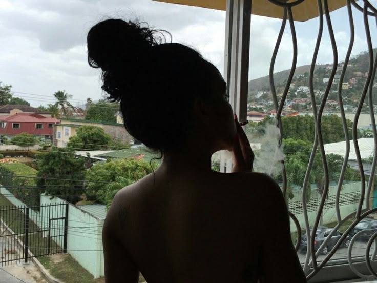 Portrait doux derrière une vitre et des volutes de fumée